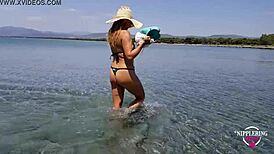 On a hot nude beach, Nippleringlover exposes her pierced pussy wide open and pisses.