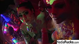 Black-Light Babes Nadia White And Ophelia Suck Colorful Cock