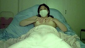 Japanese milf with big tits masturbates before bed in a chubby self-shot video.