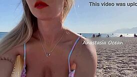 Sexy blonde shows off her stunning breasts on public beach