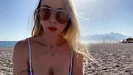 Sexy blonde shows off her stunning breasts on public beach