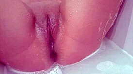 that milf bitch masturbating her shaved pussy in the bath, so steamy! 😍