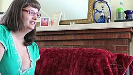 Betty, a curvy bbw with glasses, fingers her hairy pussy intensely.