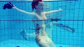 Redheaded Katrin Strips Underwater in Teasing Solo with Ripped Clothes and Tattoos