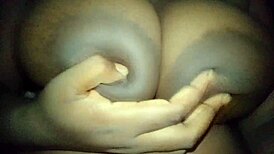 ebony woman gently touches her big busty breasts