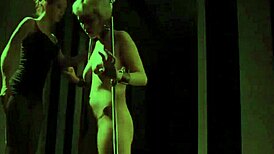 Mistress binds submissive lesbian in bondage, slapping her ass hard during intense lezdom bdsm session.