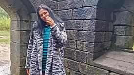 A solo female shows her naked body and urinates outside