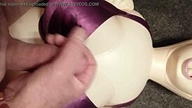 Dolly gives handjob in bra, ending with cumshot.