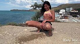 Brunette masturbates nude ass in public beach pee