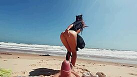 Teen brunette masturbates publicly on nude beach, caressing feet while guy jerks off and cums