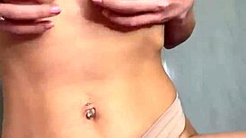 a student caresses her natural breasts at home