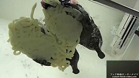 Asian babe stomps noodles in shoes for foot fetish excitement.