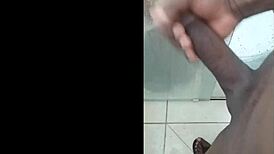 Black guy casually rubs his huge cock outdoors in public