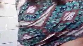 Amateur girl does striptease in bath, ripping clothes to show small tits.