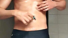 sexy guy shaving in black beach shorts
