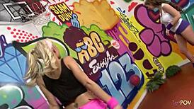 Sporty blonde and lesbian brunette dildo plug each other's pussies.