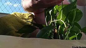 Naked Woman Waters Plants on Balcony for Curious Viewers