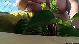 Naked Woman Waters Plants on Balcony for Curious Viewers