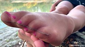 on the autumn river bank, my cute feet tease in nude tights rubbing together