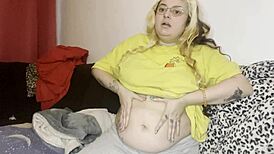 He massages her swollen hairy belly on the couch before rough play