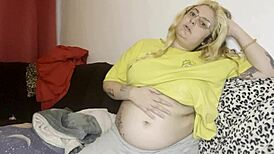 He massages her swollen hairy belly on the couch before rough play